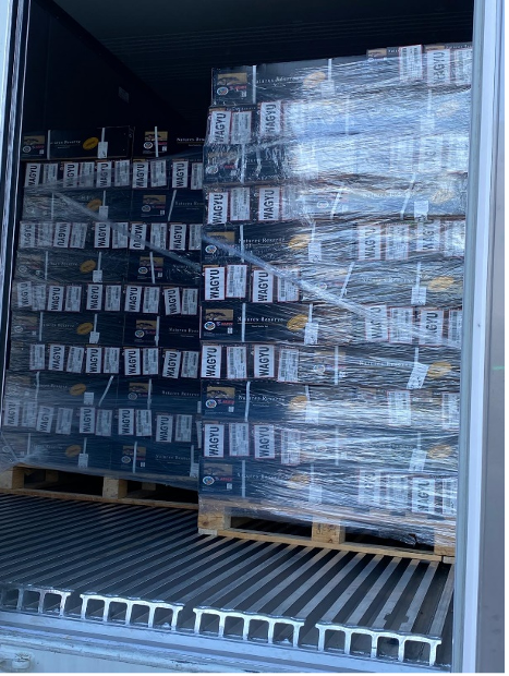 Wrapped beverage cartons on pallets inside a shipping container