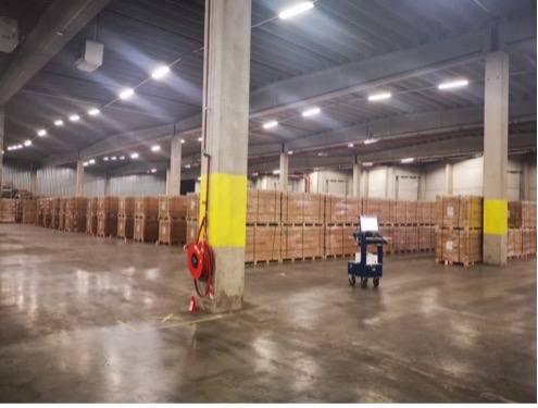 Warehouse storage hall with yellow columns and wooden crates