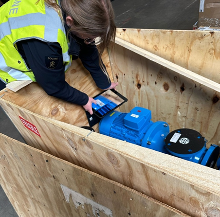 Worker inspecting machinery inside a wooden crate