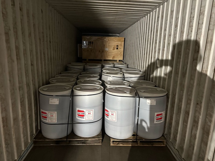 Drums and a wooden crate loaded inside a shipping container